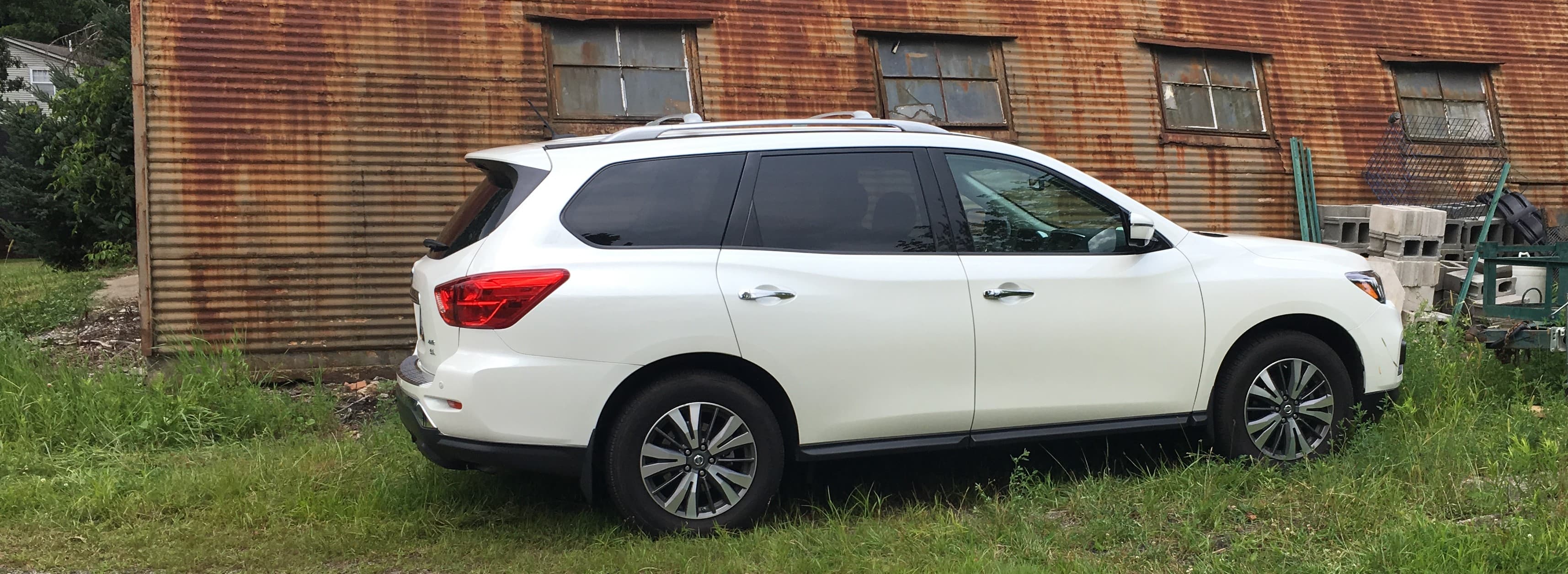 Lori's car parked behind the barn, next to the old construction debris pile